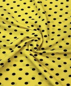 Crêpe polyester fond jaune pois noirs